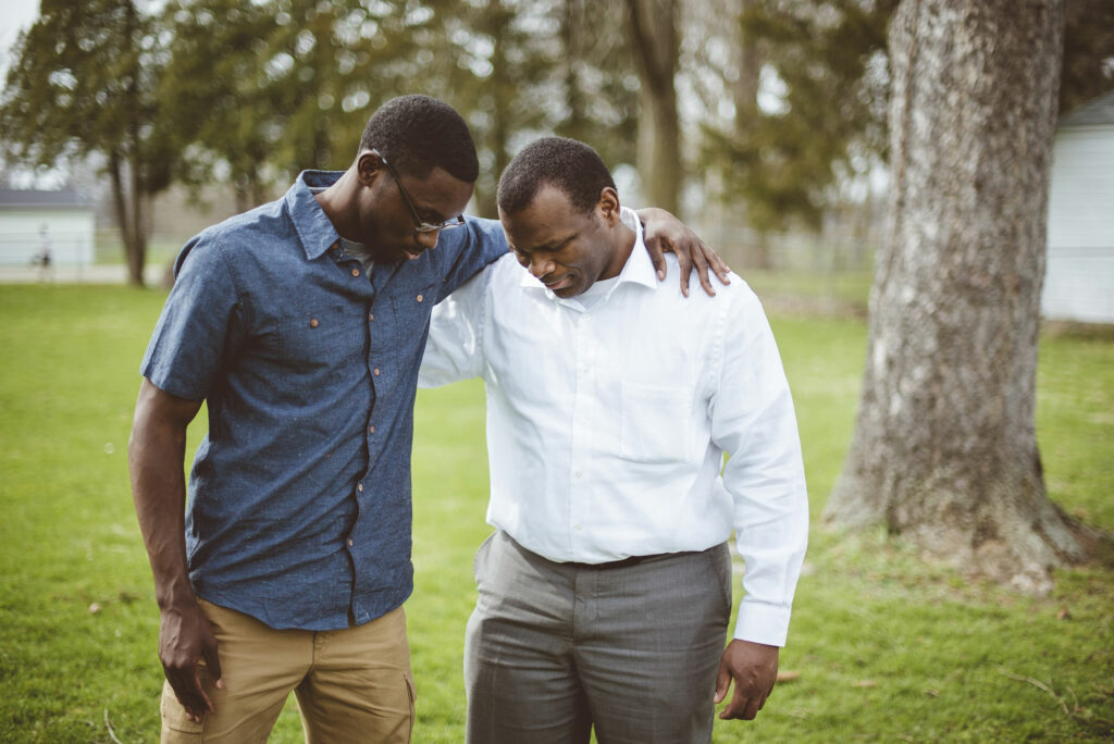 men talking and praying